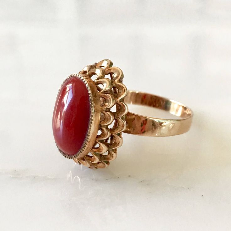 Details: Stunning vintage 14K gold Coral ring. It is a beautiful stone, and setting with lots of detail and life in it. The ring is in excellent condition with no visible flaws. Please ask all necessary questions prior to placing an order. Measurements: The size is 5 3/4 US and can be sized for a fee. The coral measures 13mm x 9mm, and has a depth of 2.2mm. Condition: The overall all condition of this ring is excellent. Elegant Red Cabochon Ruby Ring, Antique Red 14k Gold Signet Ring, Antique Red Signet Ring In 14k Gold, Vintage Red Oval Cabochon Signet Ring, Vintage Red Signet Ring With Oval Cabochon, Elegant Gold Signet Ring With Carnelian, Elegant Red Dome Ring For Formal Occasions, Elegant Red Signet Ring For Wedding, Elegant Carnelian Yellow Gold Rings