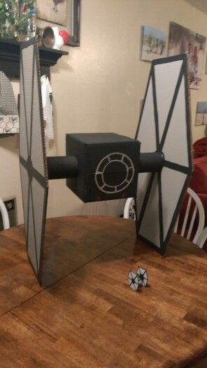 a star wars tie sitting on top of a wooden table next to a mirror that has been cut out