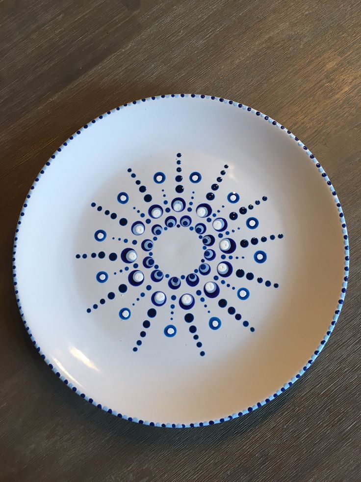 a white and blue plate sitting on top of a wooden table