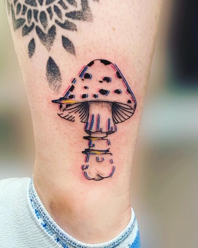 a small mushroom tattoo on the ankle