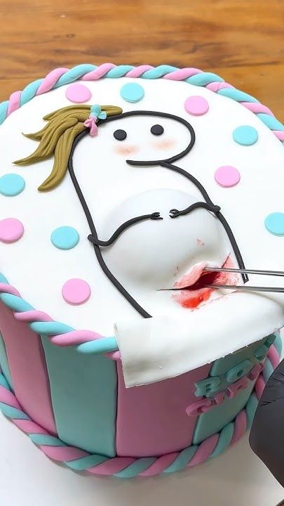 a person cutting into a decorated cake with scissors