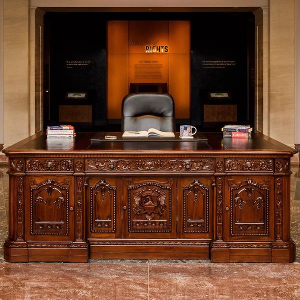 an office desk with a chair and books on it