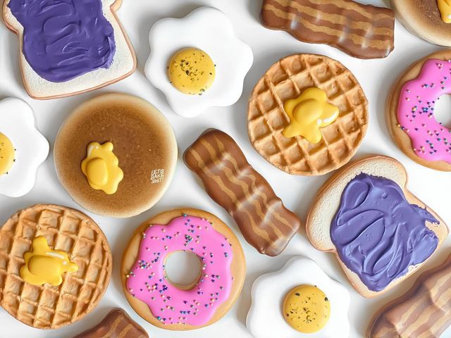 many different types of donuts and waffles on a white surface with purple icing