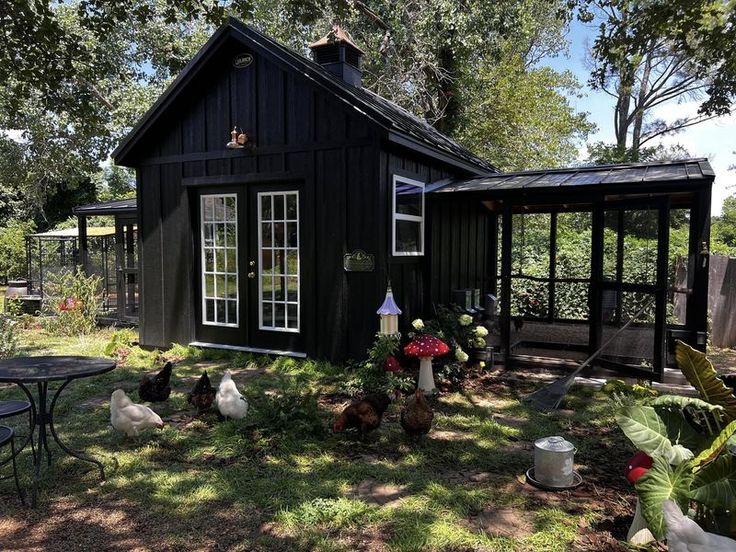 a black house with chickens in the yard