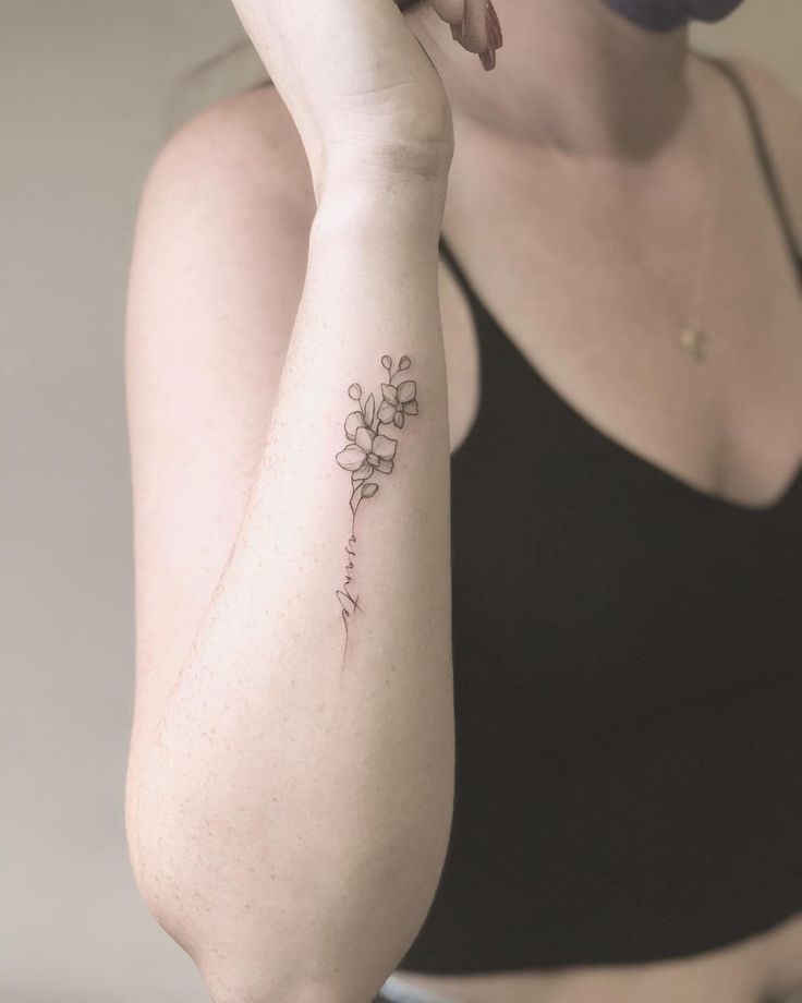 a woman with a flower tattoo on her arm