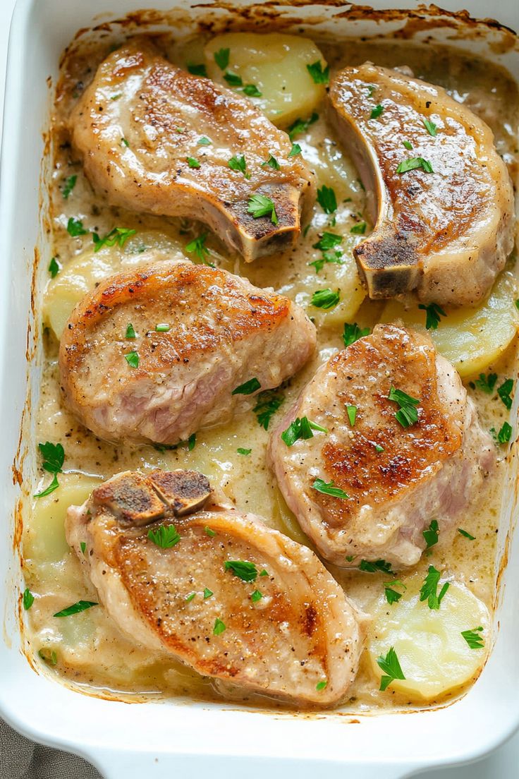 chicken and potatoes in a white casserole dish with parsley sprinkled on top