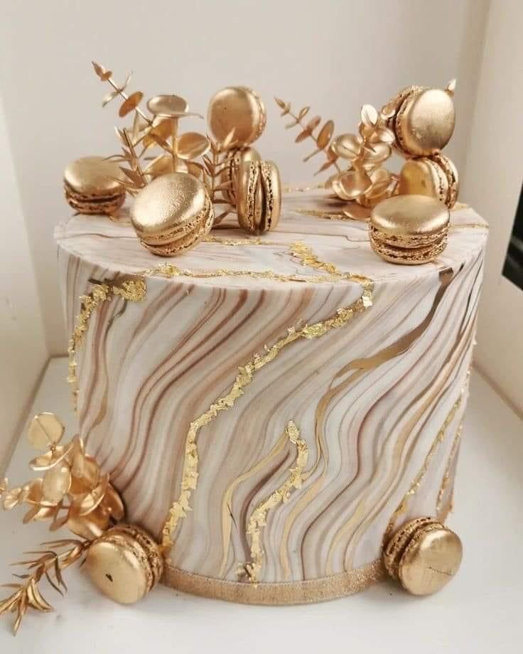 a marble cake with gold decorations on it's top and side pieces in the middle