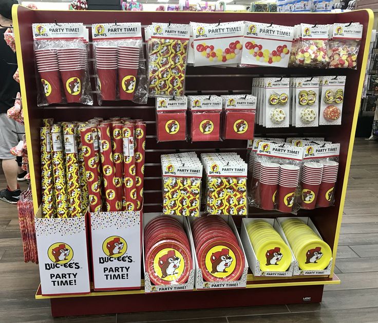 a display in a store filled with lots of red and yellow paper plates, popcorn cups, and other items