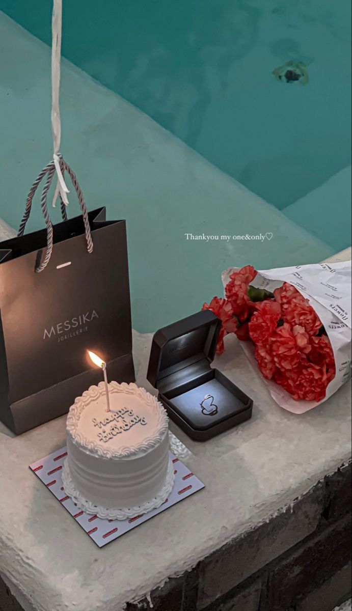 a birthday cake sitting on top of a table next to a bag