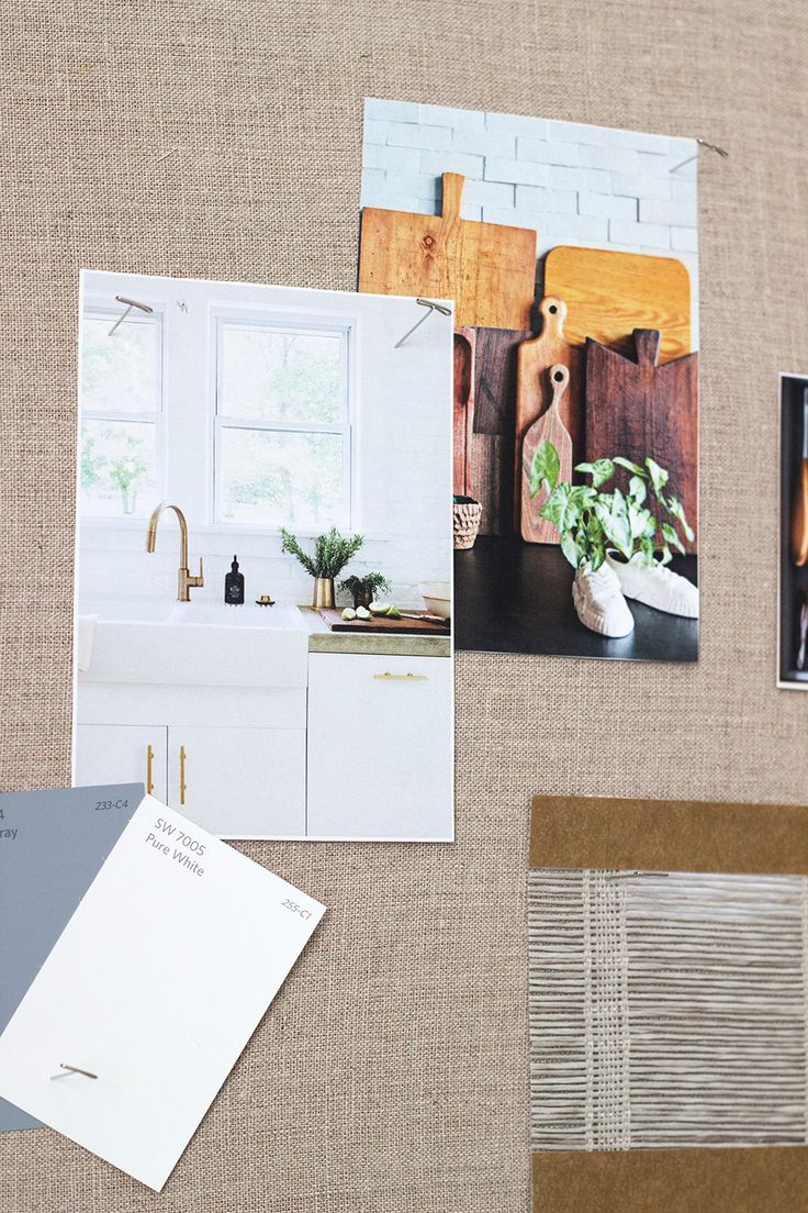 several photographs are displayed on the wall next to a kitchen sink and counter top, along with other items