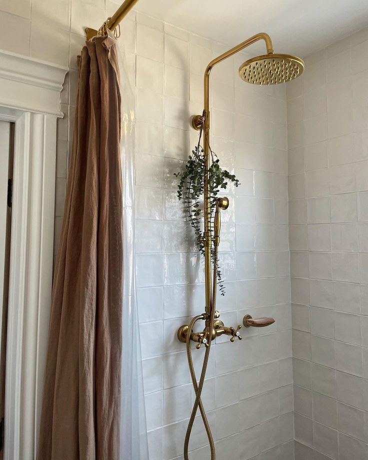 a shower head and hand held shower faucet in the corner of a bathroom