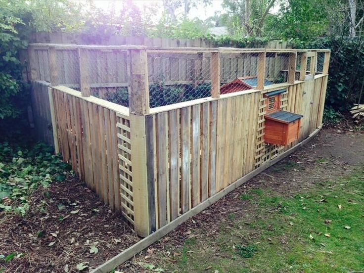 a wooden fenced in area with some trash cans