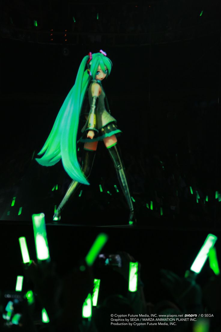 a woman with long green hair is performing on stage