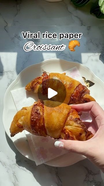 a person is holding up some food on a plate with the words virtual rice paper croissant