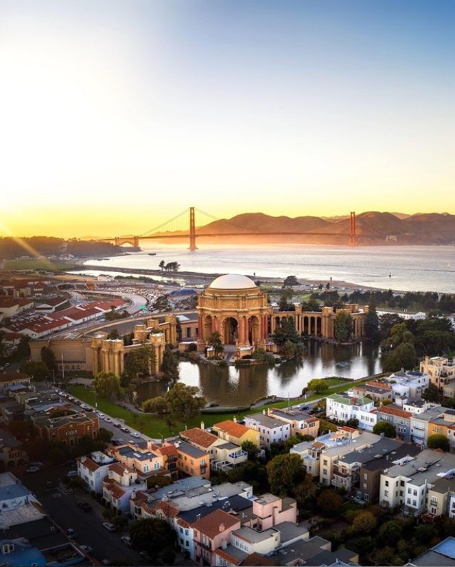 an aerial view of san francisco with the golden gate bridge in the background at sunset