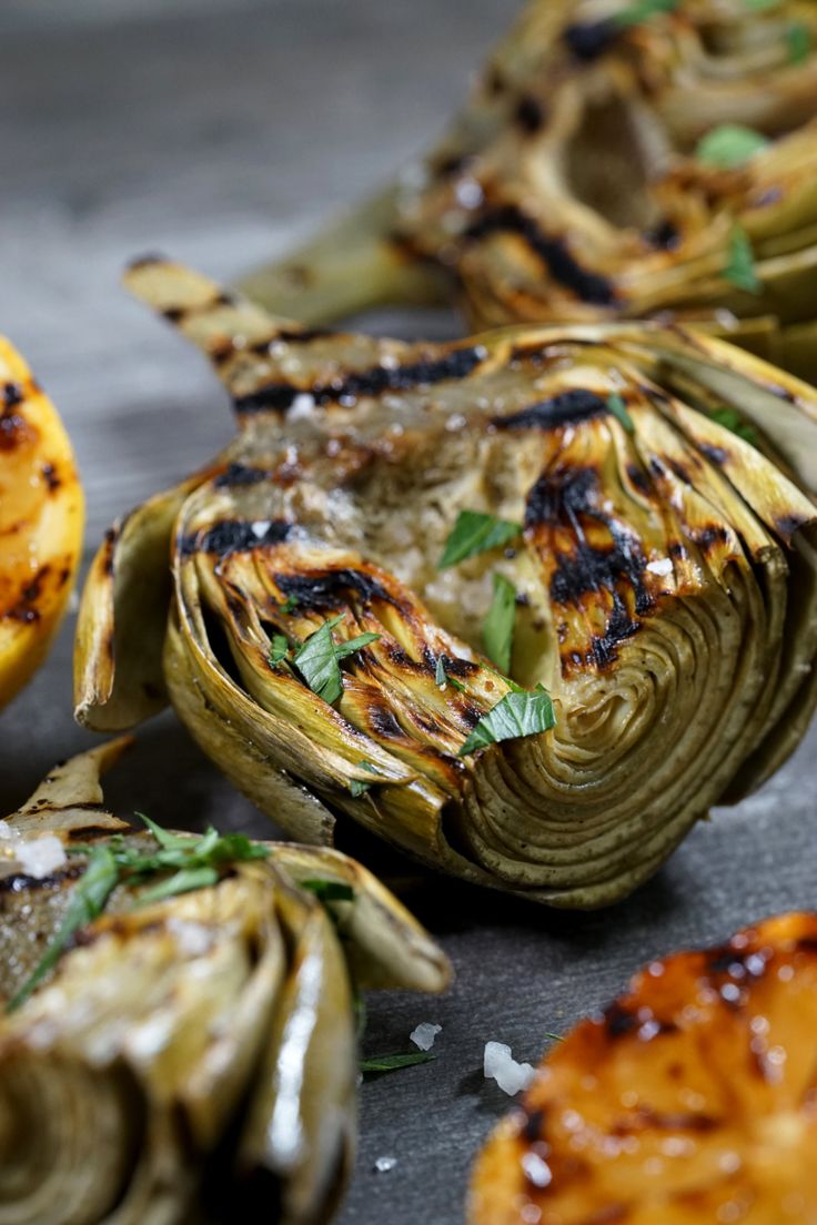 grilled artichokes with lemon and herbs on the side, ready to be eaten