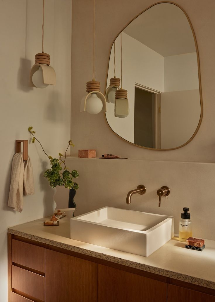 a bathroom with a sink, mirror and hanging lights