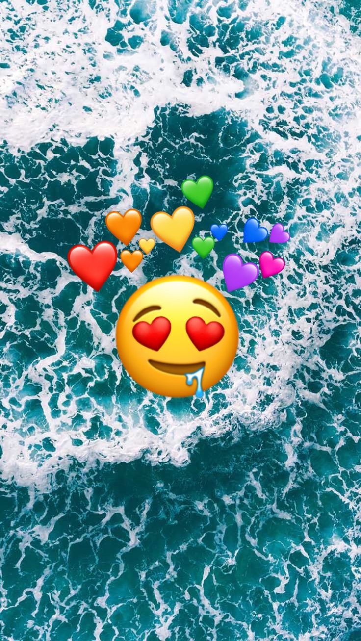 an emoticive smiley face floating in the ocean surrounded by hearts