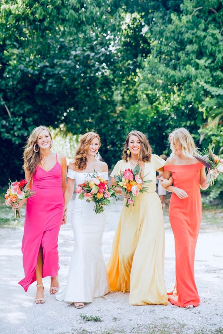 four bridesmaids in different colored dresses walking together