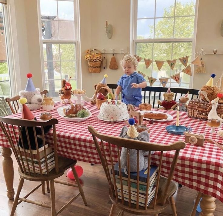 a little boy that is standing in front of a table with some food on it