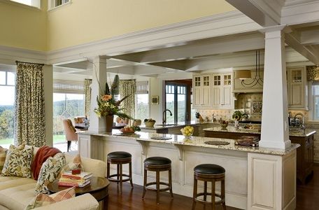 a living room filled with furniture next to a kitchen and breakfast nook in a home