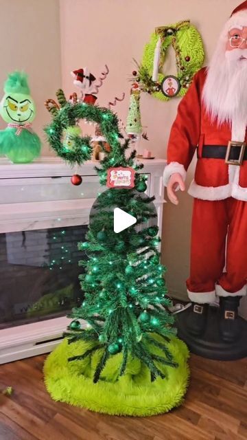 a santa clause standing next to a christmas tree