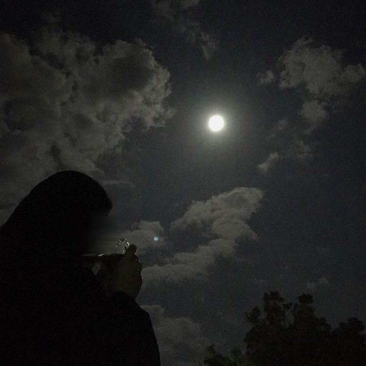 a person is looking up at the moon