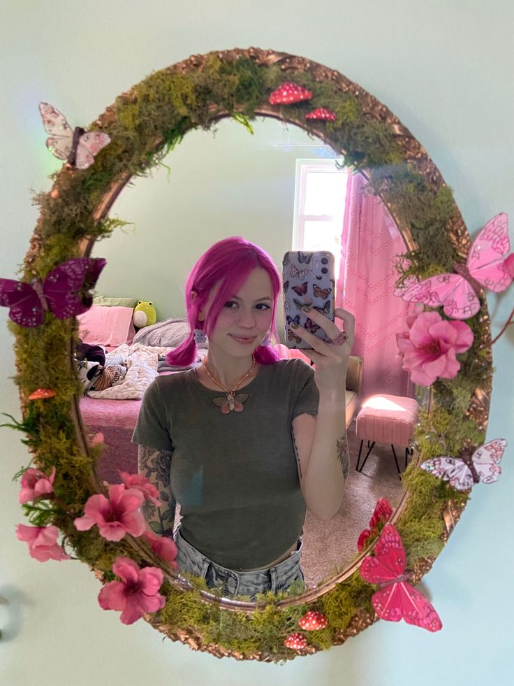 a woman taking a selfie in front of a mirror with pink flowers on it