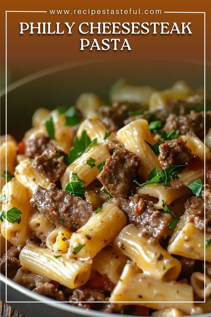 pasta with meat and parsley in a white bowl on a wooden table, text reads phily cheesesteak pasta