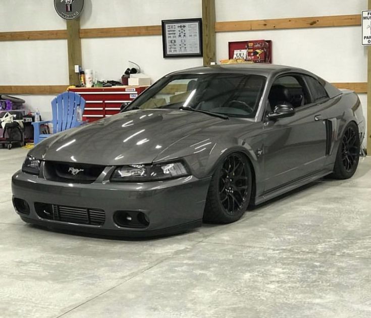 a gray mustang car parked in a garage