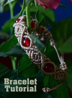 the bracelet is decorated with beads and garnished with red glass stones, on top of a green leaf