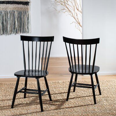 two black chairs sitting next to each other on a rug