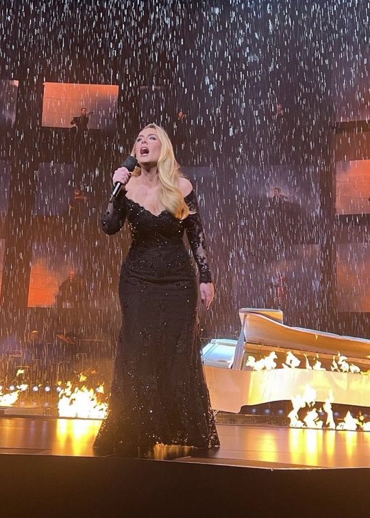 a woman standing on top of a stage holding a microphone