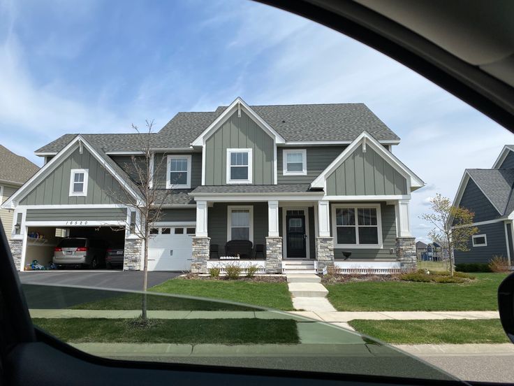 a car is parked in front of a house with two garages on each side