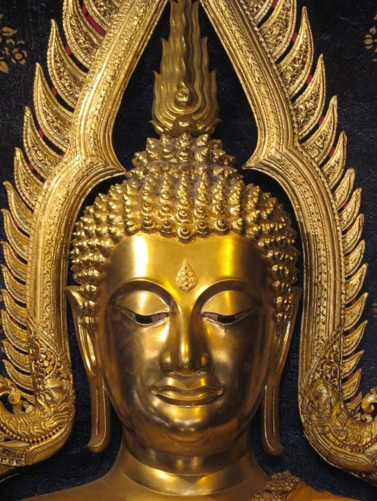 a golden buddha statue sitting on top of a table