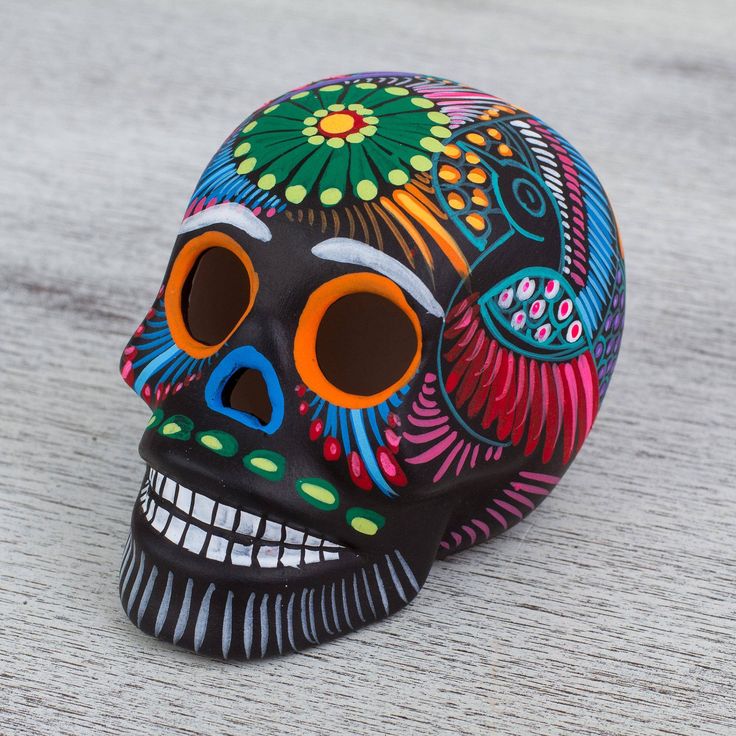 a colorfully painted skull sitting on the ground