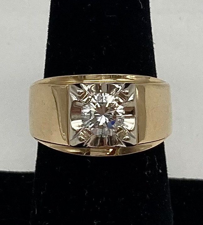 a yellow gold ring with a diamond in the center on a black velvet display stand