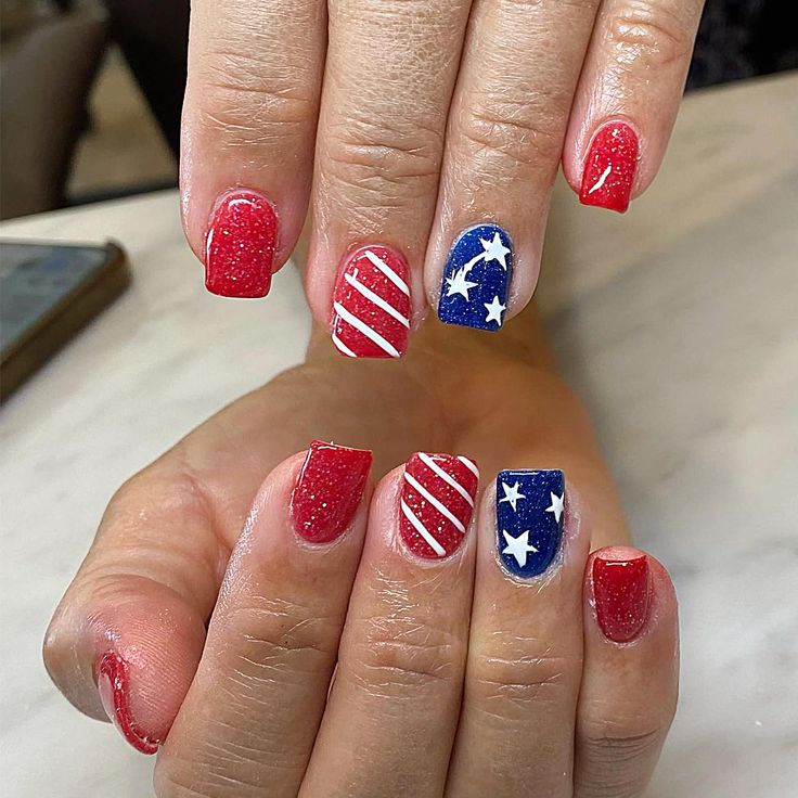 two hands with red, white and blue nail designs on them