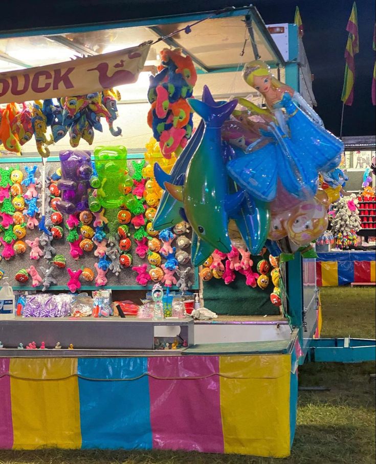 a carnival booth with balloons and stuffed animals