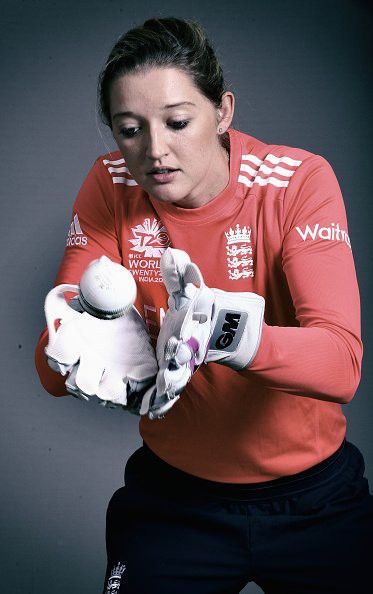 a woman in red shirt holding a white glove