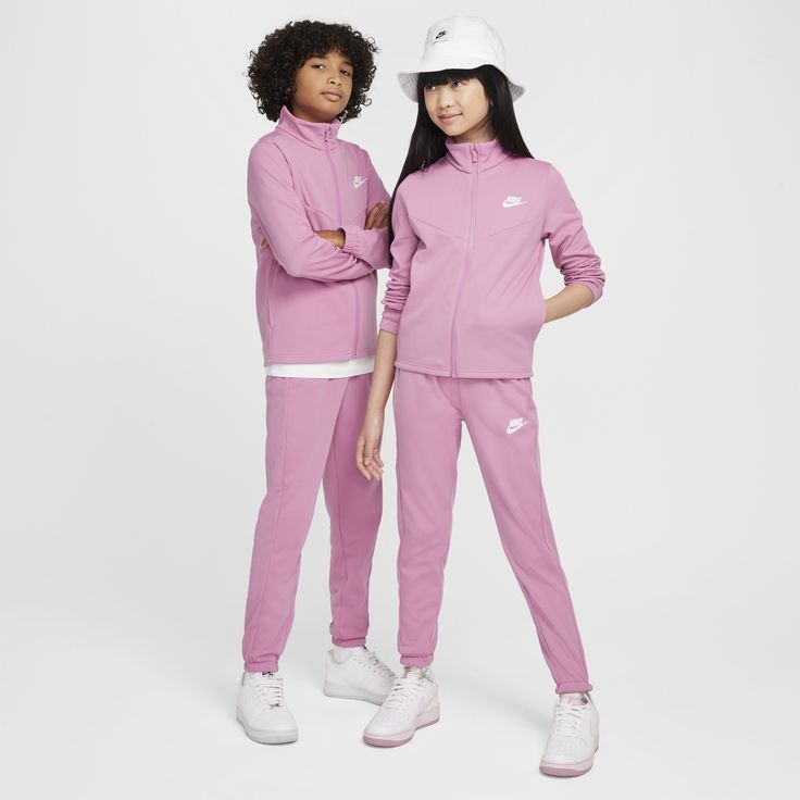 Get up and get going in a flash with the help of this matching outfit. Smooth on the outside and brushed on the inside for added comfort, the cozy knit fabric delivers a classic tracksuit look and an extra soft feel. A subtle nod to Nike heritage, the v-shaped chevron design lines on the chest set you up with a classic Windrunner look. Pink Sporty Activewear For Leisure, Pink Fleece Sweats In Athleisure Style, Nike Sportswear Tracksuit For Jogging, Sporty Pink Sweats For Jogging, Casual Pink Tracksuit For Jogging, Pink Casual Sweats For Sports, Casual Pink Sweats For Sports, Pink Sporty Sweats For Jogging, Winter Jogging Athleisure Sets