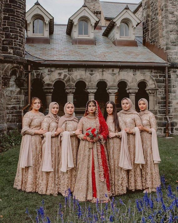 a group of women standing next to each other in front of a building