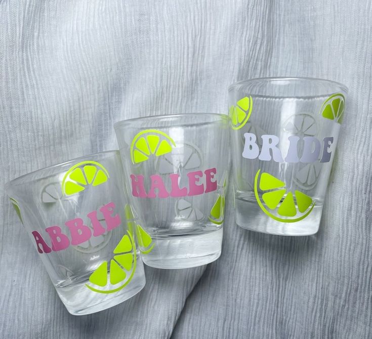 three personalized shot glasses with limes and lemon wedges on the side, one for bride