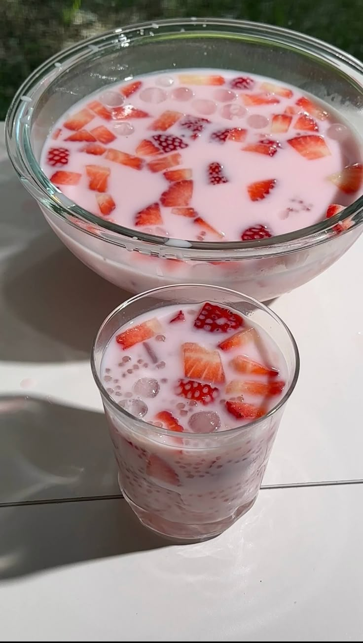 two glasses filled with yogurt and strawberries