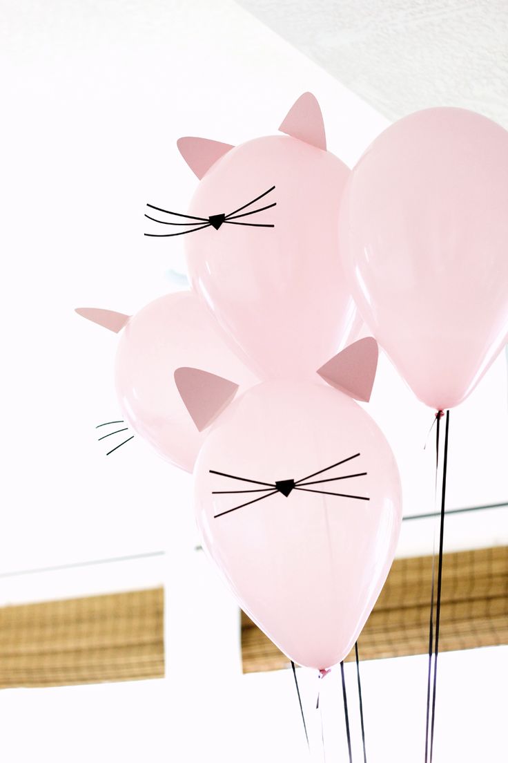 three pink balloons with cat ears on them