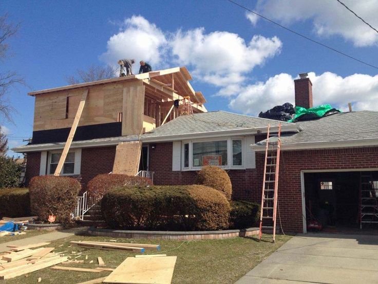 two men are working on the roof of a house that's under construction,