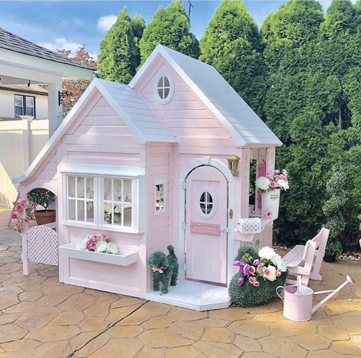 a pink doll house sitting on top of a patio