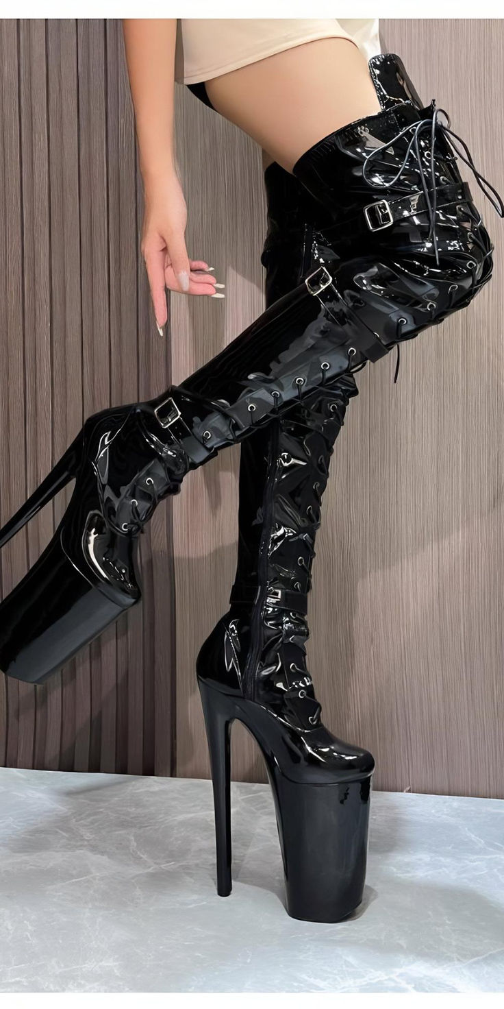 Elevate your style with these bold black platform boots, featuring striking lacing and ultra-high heels for a look that's both daring and sophisticated. Ideal for those who love statement footwear, these thigh-high boots combine avant-garde style with a modern edge, making them a standout addition to any fashion-forward wardrobe. Perfect for adding a touch of drama to your special events or nights out. Gothic Black Boots For Club, Gothic Boots For Night Out In Winter, Edgy Lace-up Boots For Club, Edgy Lace-up Club Boots, Chic High Ankle Boots For Club, Thigh High Platform Heeled Boots For Night Out, Gothic Winter Club Boots, Gothic Thigh High Boots For Party, Chic Over-the-knee Boots For Club