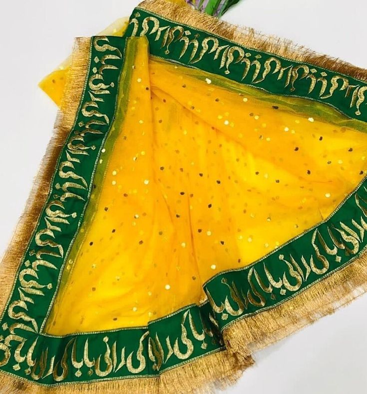 a yellow and green shawl with writing on it