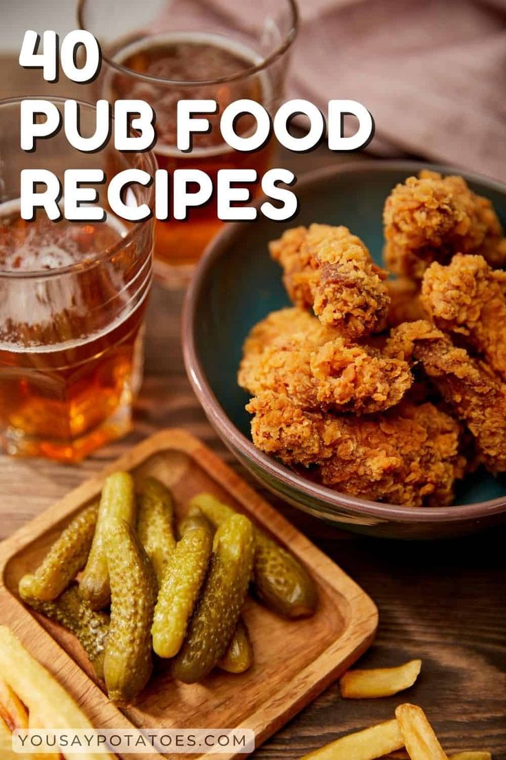 some fried food is sitting on a table next to glasses and a plate with pickles